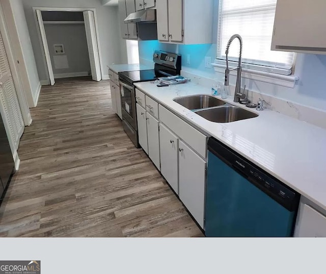 kitchen with appliances with stainless steel finishes, light hardwood / wood-style flooring, white cabinetry, and sink