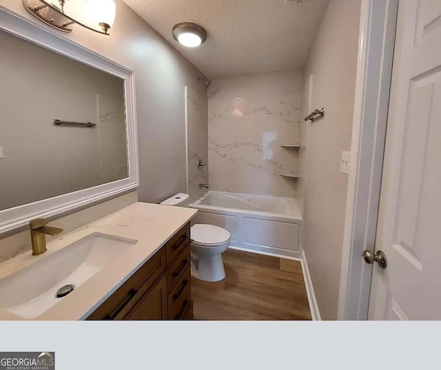 full bathroom featuring hardwood / wood-style floors, shower / bath combination, a textured ceiling, toilet, and vanity with extensive cabinet space