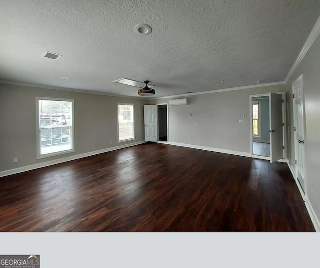 unfurnished room featuring ornamental molding, dark wood-type flooring, an AC wall unit, and a healthy amount of sunlight