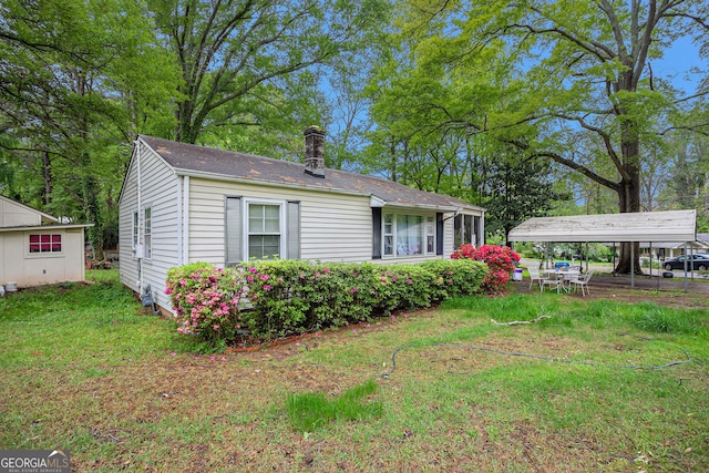 view of front of house with a carport and a front lawn