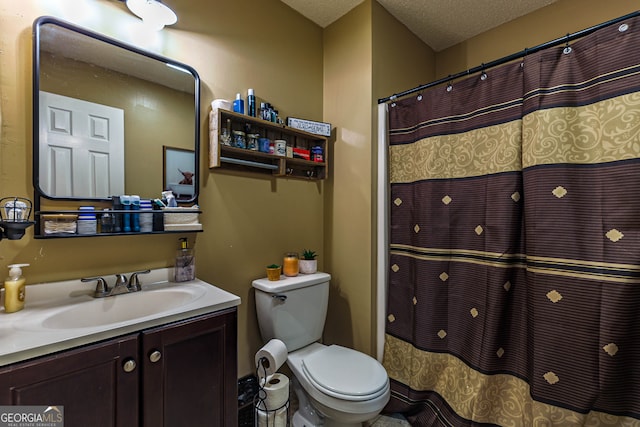 bathroom with a textured ceiling, toilet, and large vanity