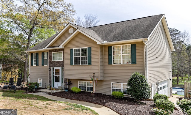 split foyer home featuring a playground and a garage