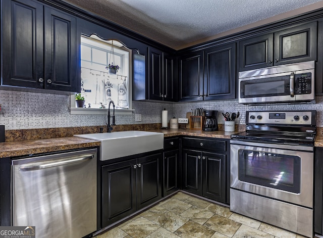 kitchen with appliances with stainless steel finishes, backsplash, light tile floors, a textured ceiling, and sink