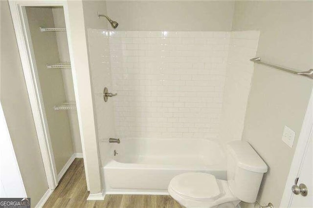 bathroom with shower / bath combination, hardwood / wood-style floors, and toilet