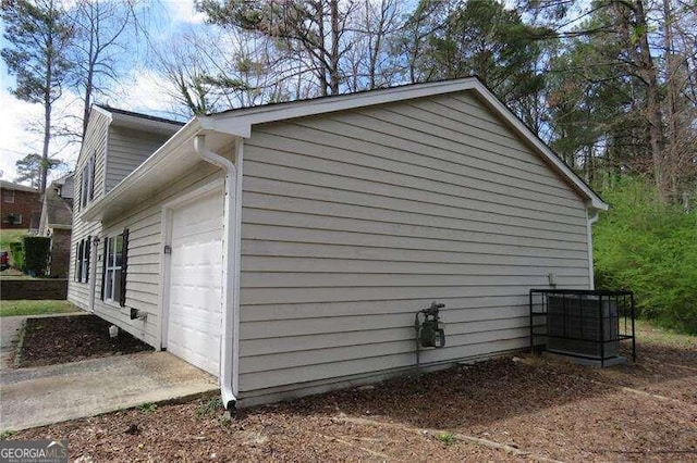 view of property exterior featuring central AC unit and a garage