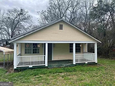 bungalow-style home featuring a porch and a front lawn