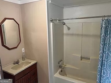 bathroom with shower / bath combo and vanity with extensive cabinet space