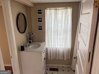 bathroom with tile flooring and vanity with extensive cabinet space