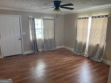 spare room featuring ceiling fan, a textured ceiling, and dark hardwood / wood-style floors