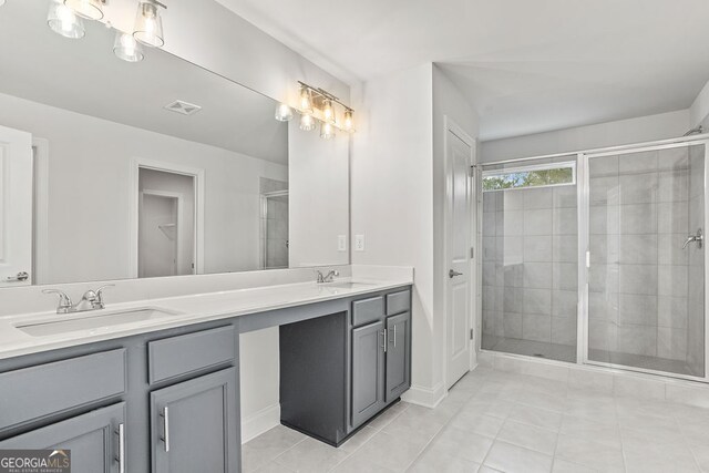 bathroom featuring tile patterned flooring, vanity, and a shower with door