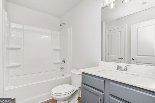 full bathroom with toilet, hardwood / wood-style floors, vanity, and bathing tub / shower combination