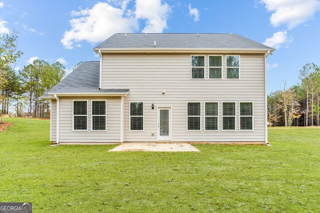 rear view of property featuring a patio area and a lawn