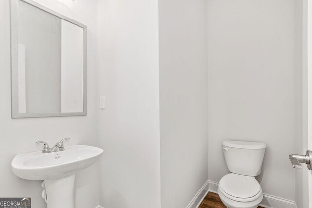 bathroom with sink, wood-type flooring, and toilet