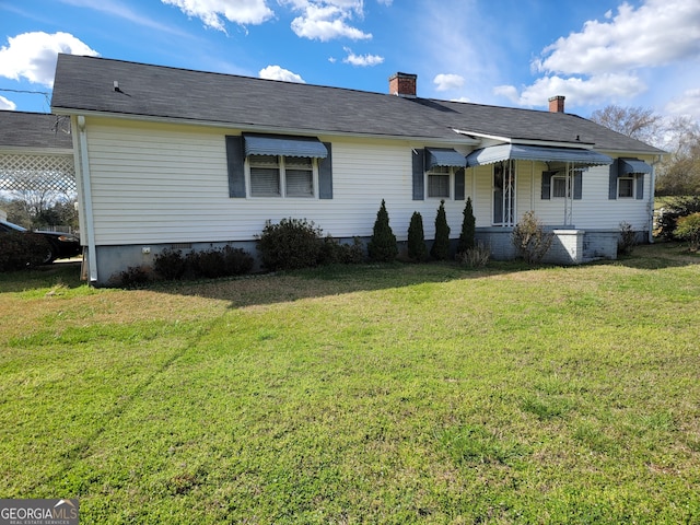 rear view of property featuring a yard