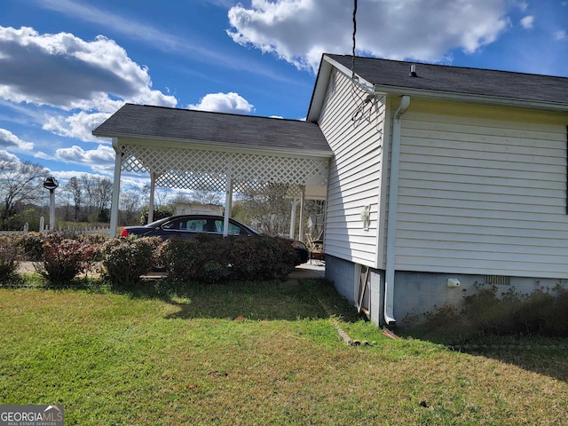 view of side of home with a carport and a lawn