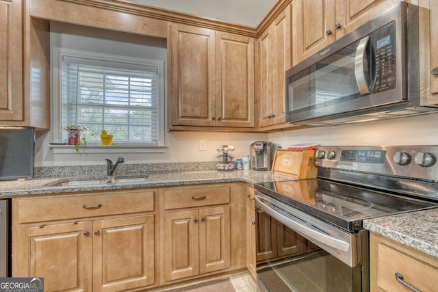 kitchen with light stone counters, sink, and stainless steel appliances