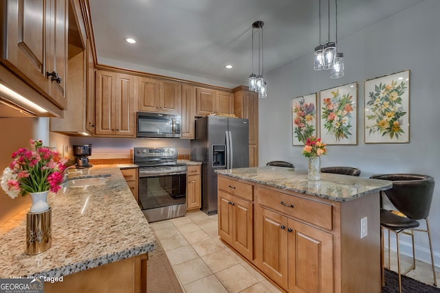 kitchen featuring a center island, a kitchen bar, appliances with stainless steel finishes, light tile patterned floors, and light stone counters