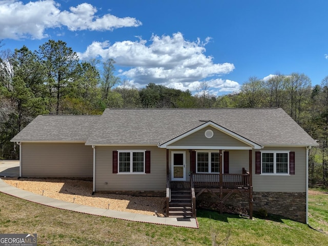 ranch-style home featuring covered porch and a front lawn