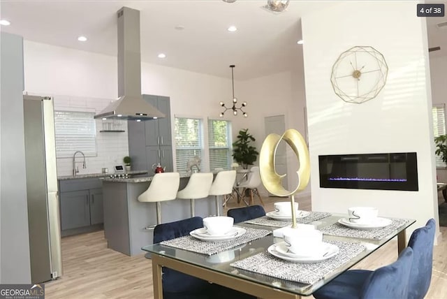 dining room with a chandelier, light hardwood / wood-style flooring, and sink