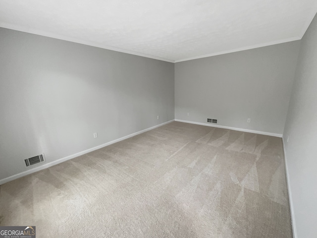 unfurnished room with ornamental molding and light carpet