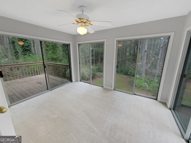 unfurnished sunroom featuring a healthy amount of sunlight and ceiling fan