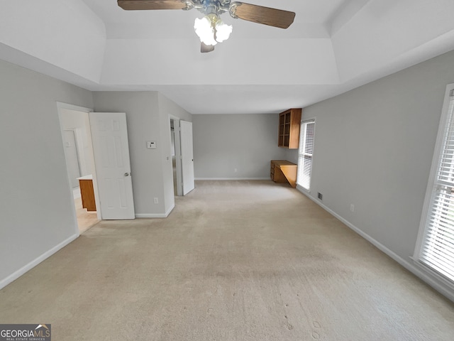 interior space featuring light colored carpet, ceiling fan, and a tray ceiling