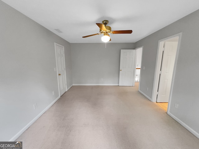 carpeted empty room featuring ceiling fan