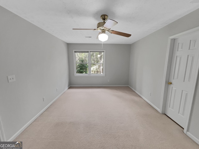 empty room with light colored carpet and ceiling fan