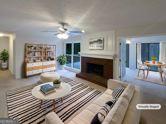 carpeted living room with ornamental molding, ceiling fan, and a brick fireplace