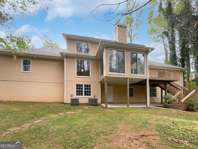 back of house featuring a deck, a lawn, central air condition unit, and a patio area