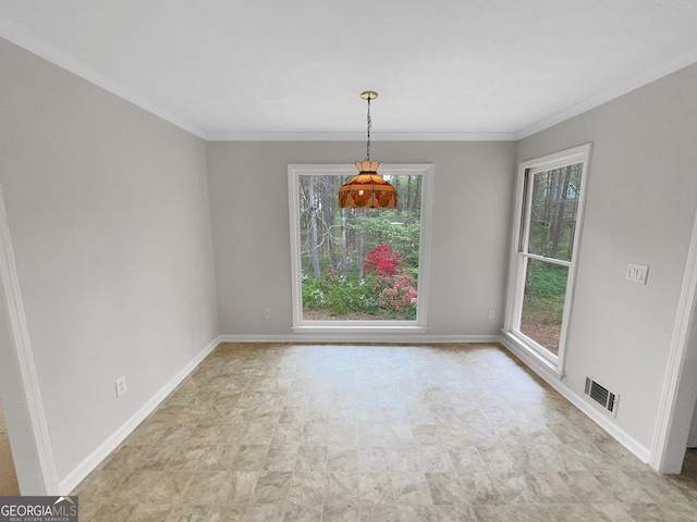 spare room with plenty of natural light, light tile floors, and ornamental molding