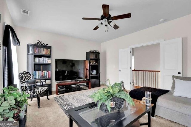 carpeted living room with ceiling fan