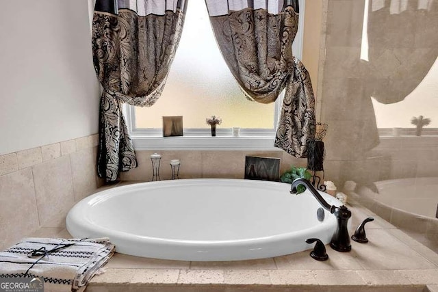 bathroom featuring a relaxing tiled bath