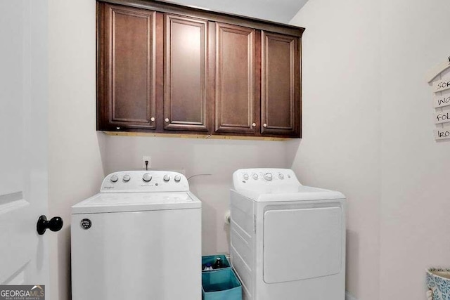 laundry room with washing machine and dryer and cabinets