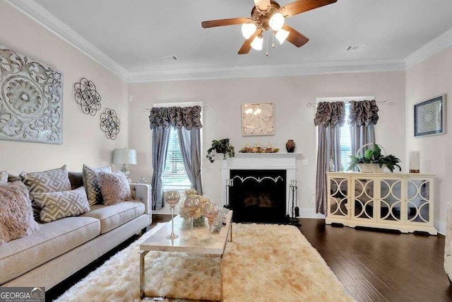 living room with ornamental molding, dark wood-type flooring, and ceiling fan