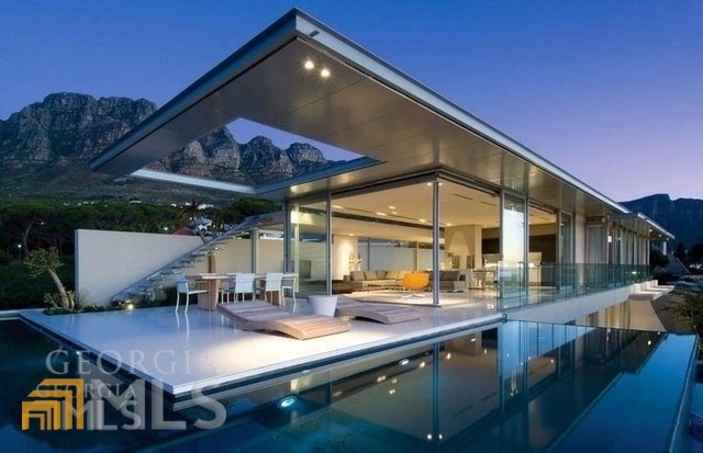 rear view of house with a patio and a mountain view