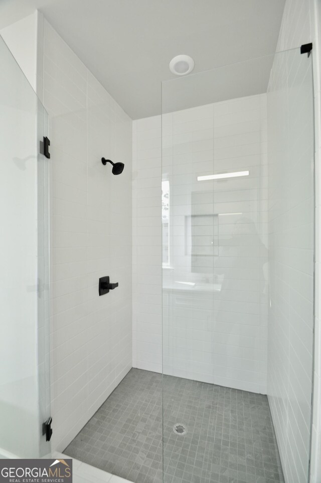 bathroom featuring a shower with door