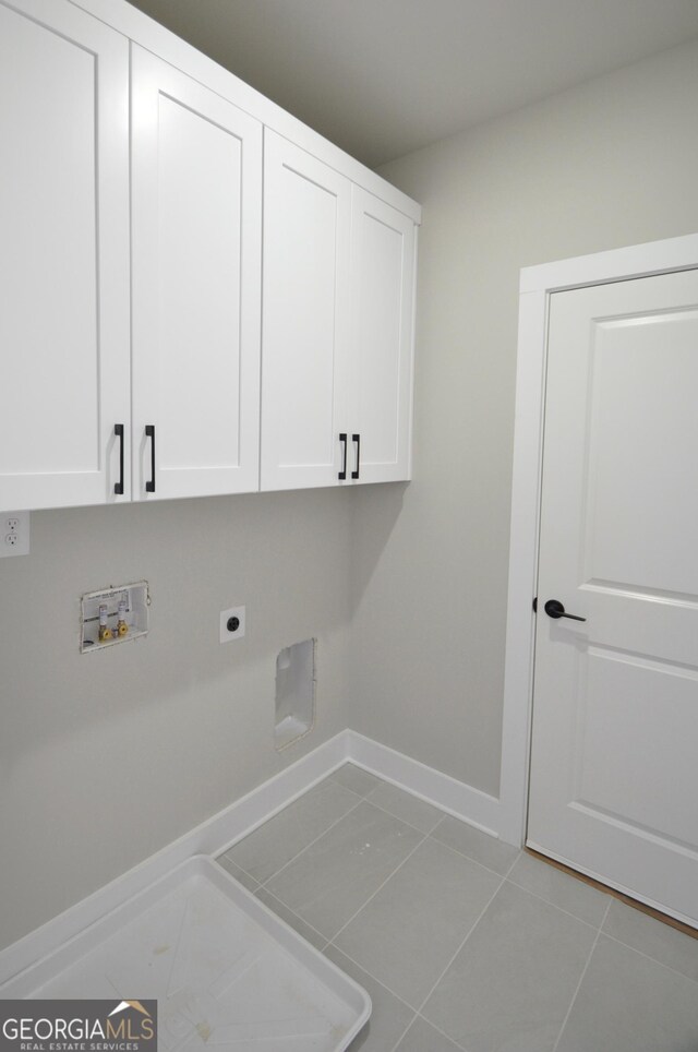 washroom featuring hookup for a washing machine, light tile patterned floors, cabinets, and hookup for an electric dryer