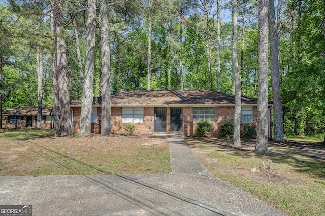 ranch-style home featuring brick siding and a front lawn