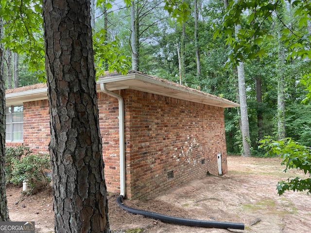 view of property exterior featuring crawl space and brick siding