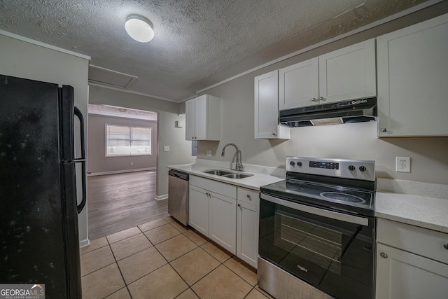 kitchen with white cabinets, stainless steel appliances, light countertops, under cabinet range hood, and a sink