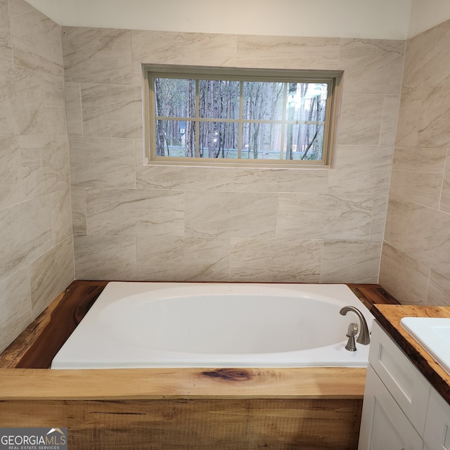 bathroom featuring tile walls, vanity, and a bathtub