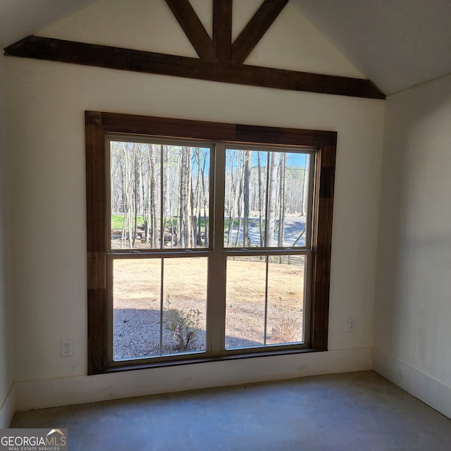 spare room featuring vaulted ceiling with beams