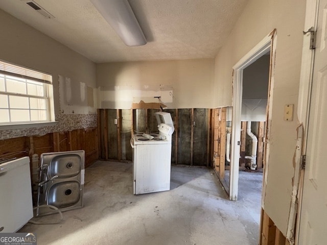 spare room with ceiling fan, a textured ceiling, light colored carpet, and a healthy amount of sunlight