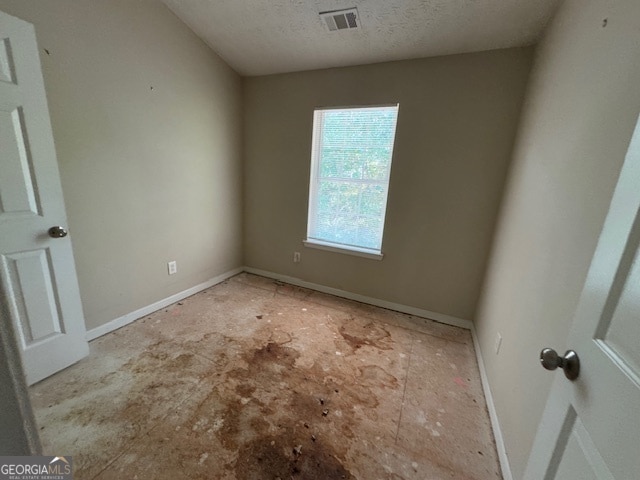 interior space with a textured ceiling and light carpet