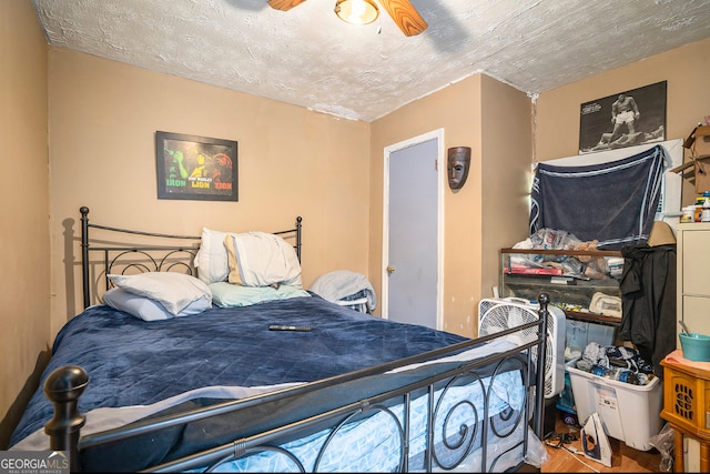 bedroom with ceiling fan, light hardwood / wood-style flooring, and a textured ceiling