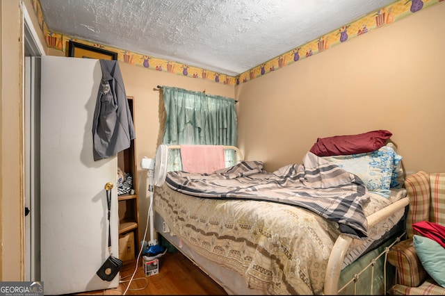 bedroom with a textured ceiling and dark wood-type flooring