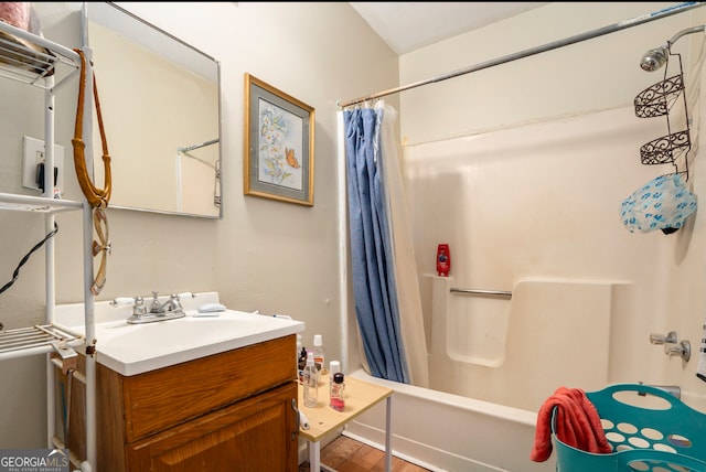 bathroom featuring wood-type flooring, oversized vanity, and shower / bath combo