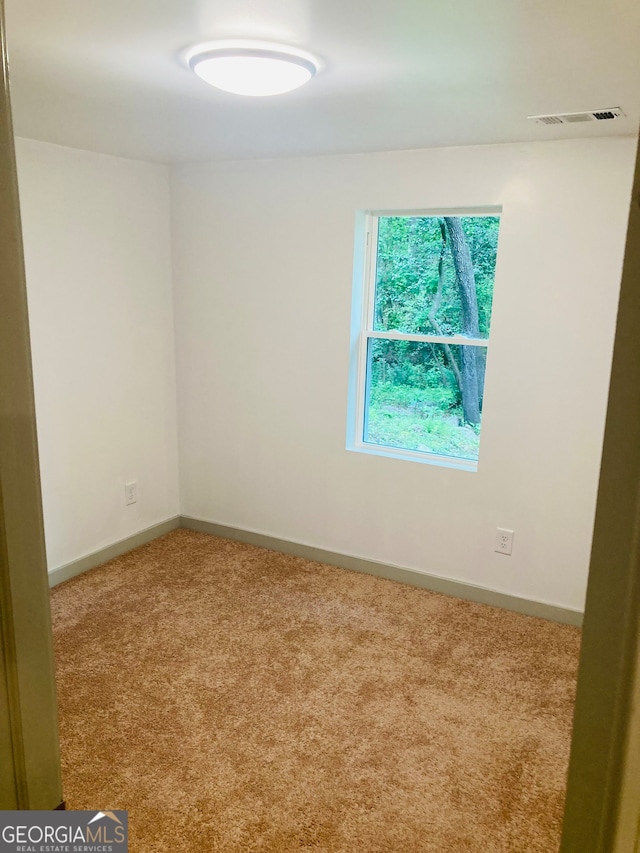 unfurnished room featuring light carpet