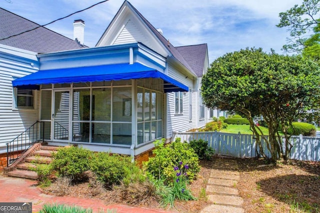315 Dixie St, Carrollton, GA 30117 - view of property exterior featuring a sunroom, a shingled roof, and fence